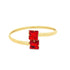A sleek gold bangle bracelet features two vibrant square-cut red stones set end-to-end at the center.