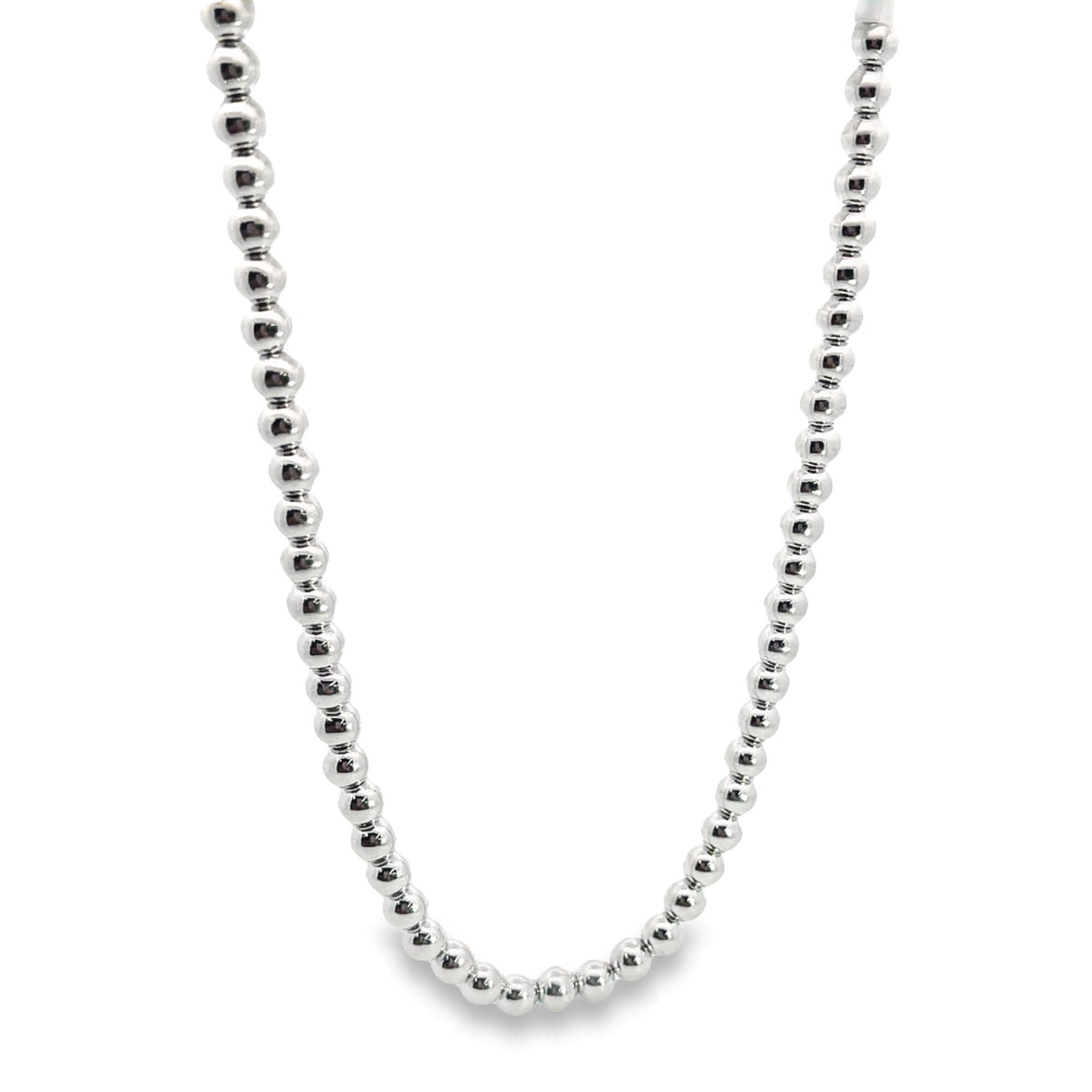 A shiny silver ball bead necklace hangs against a plain white background.