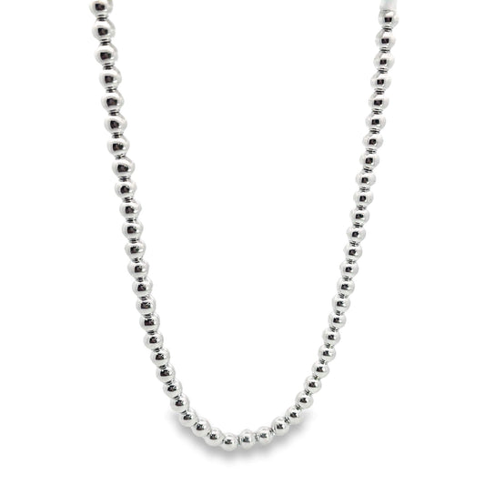 A shiny silver ball bead necklace hangs against a plain white background.