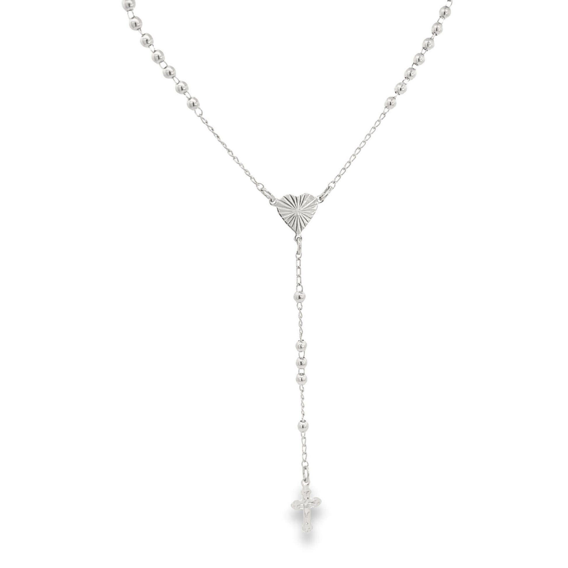 A delicate silver rosary necklace features small ball beads, a sunburst-textured heart centerpiece, and a matching crucifix pendant.