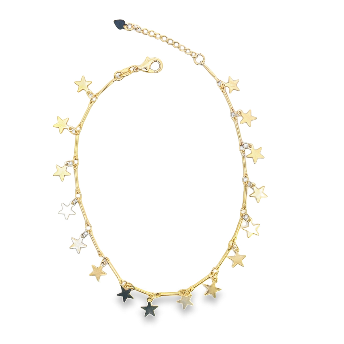 A delicate gold star charm necklace rests against a plain white background, featuring dangling celestial charms in yellow, white, and black metal.