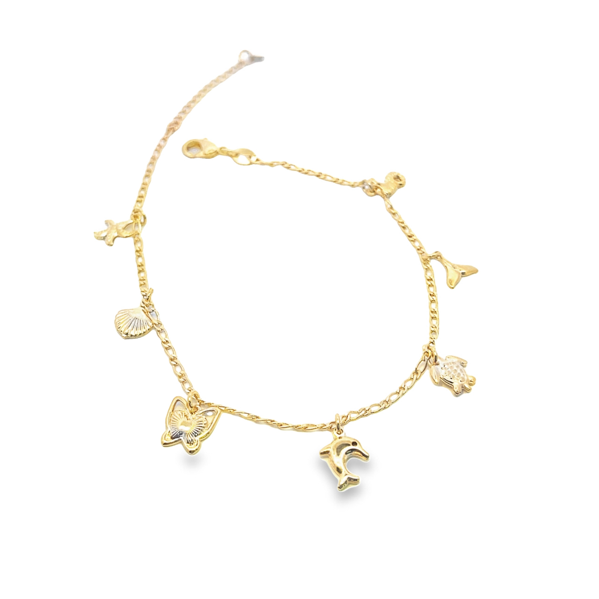 A delicate gold charm bracelet displays hanging sea-themed trinkets, including a dolphin, turtle, and seashell against a clean white background.