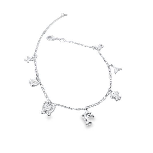 A sterling silver charm bracelet features dangling oceanic charms including a dolphin, turtle, and seashells against a white background.