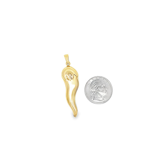 A polished gold Italian horn pendant rests beside a US quarter for scale.