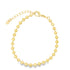 A delicate gold bead bracelet curves gracefully against a plain white background, featuring an adjustable chain with a tiny heart charm.