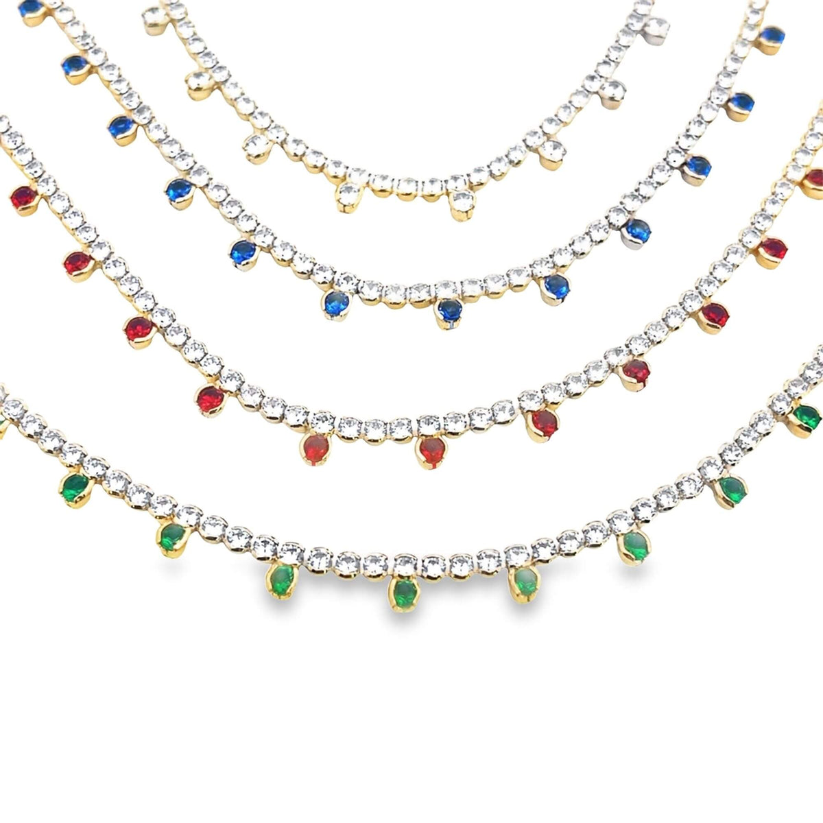 Four cascading rhinestone tennis necklaces display dangling gemstone charms in clear, blue, red, and green against a white background.