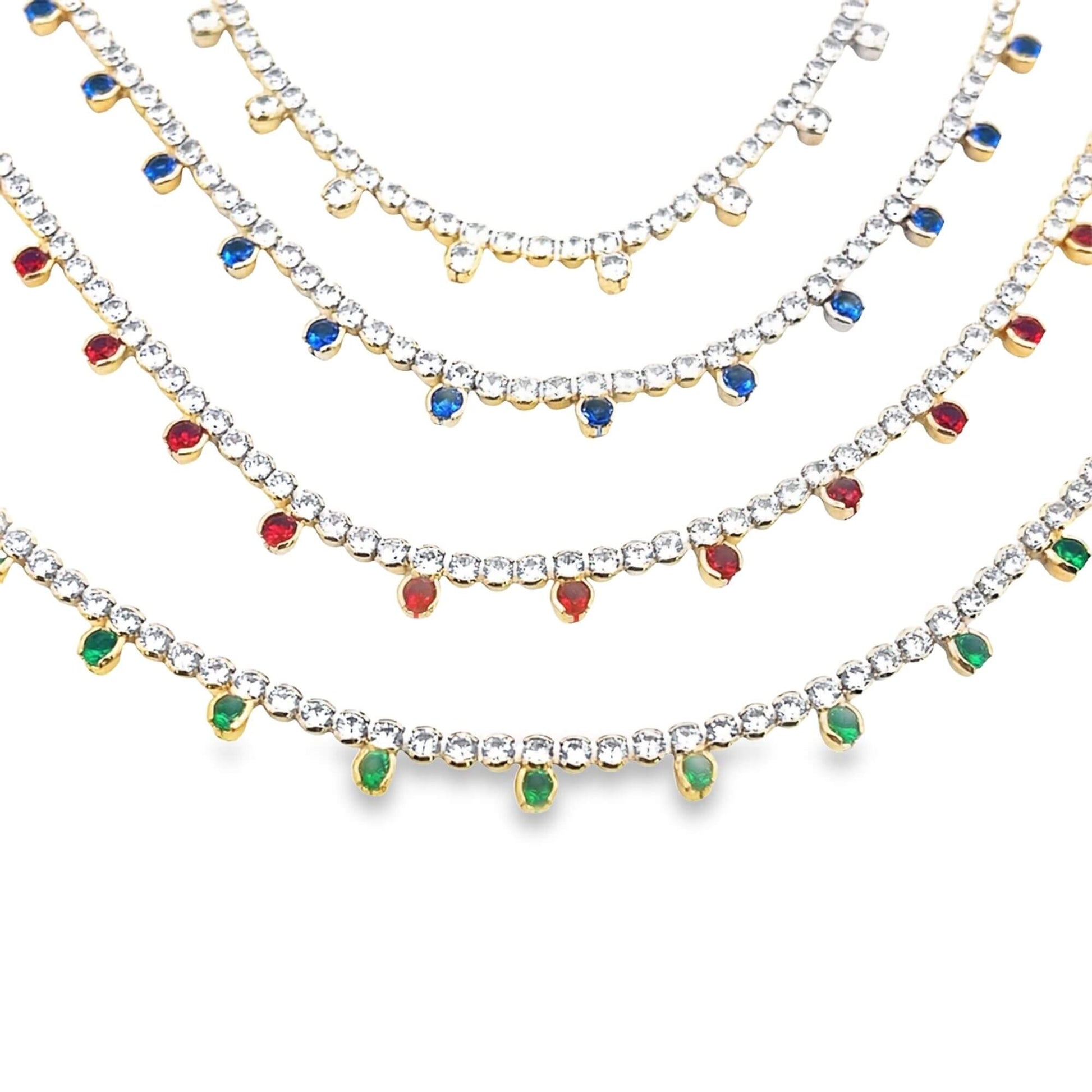 Four cascading rhinestone tennis necklaces display dangling gemstone charms in clear, blue, red, and green against a white background.