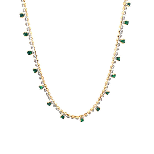 A delicate gold necklace sparkles with clear rhinestones and hanging green gemstone drops against a clean white background.