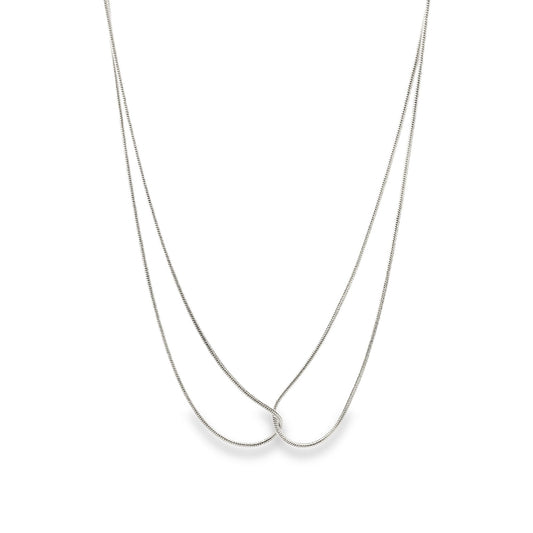 A delicate silver snake chain necklace gracefully loops and intertwines against a clean white background.