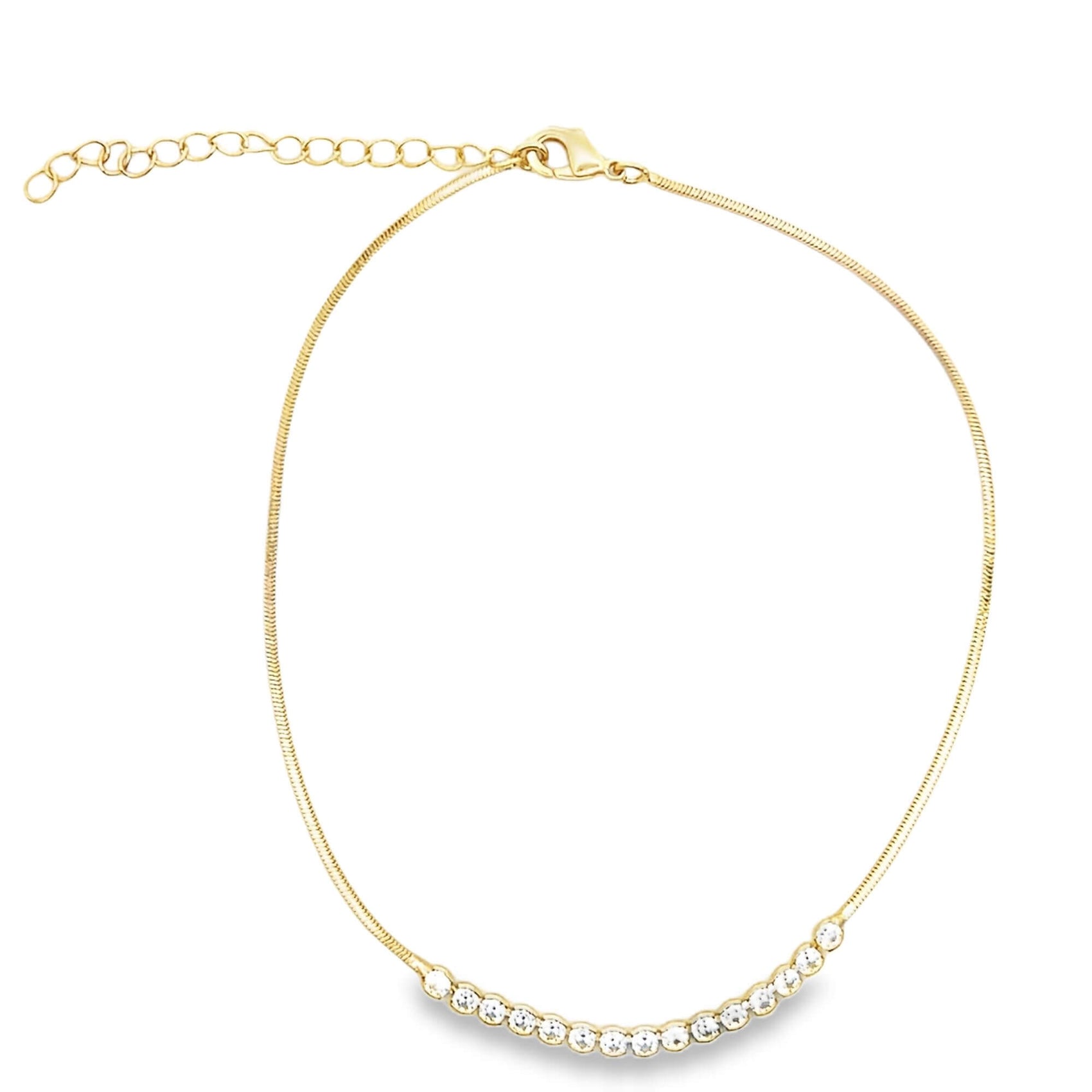 A delicate gold chain necklace sparkles with a curved row of cubic zirconia stones at the center.