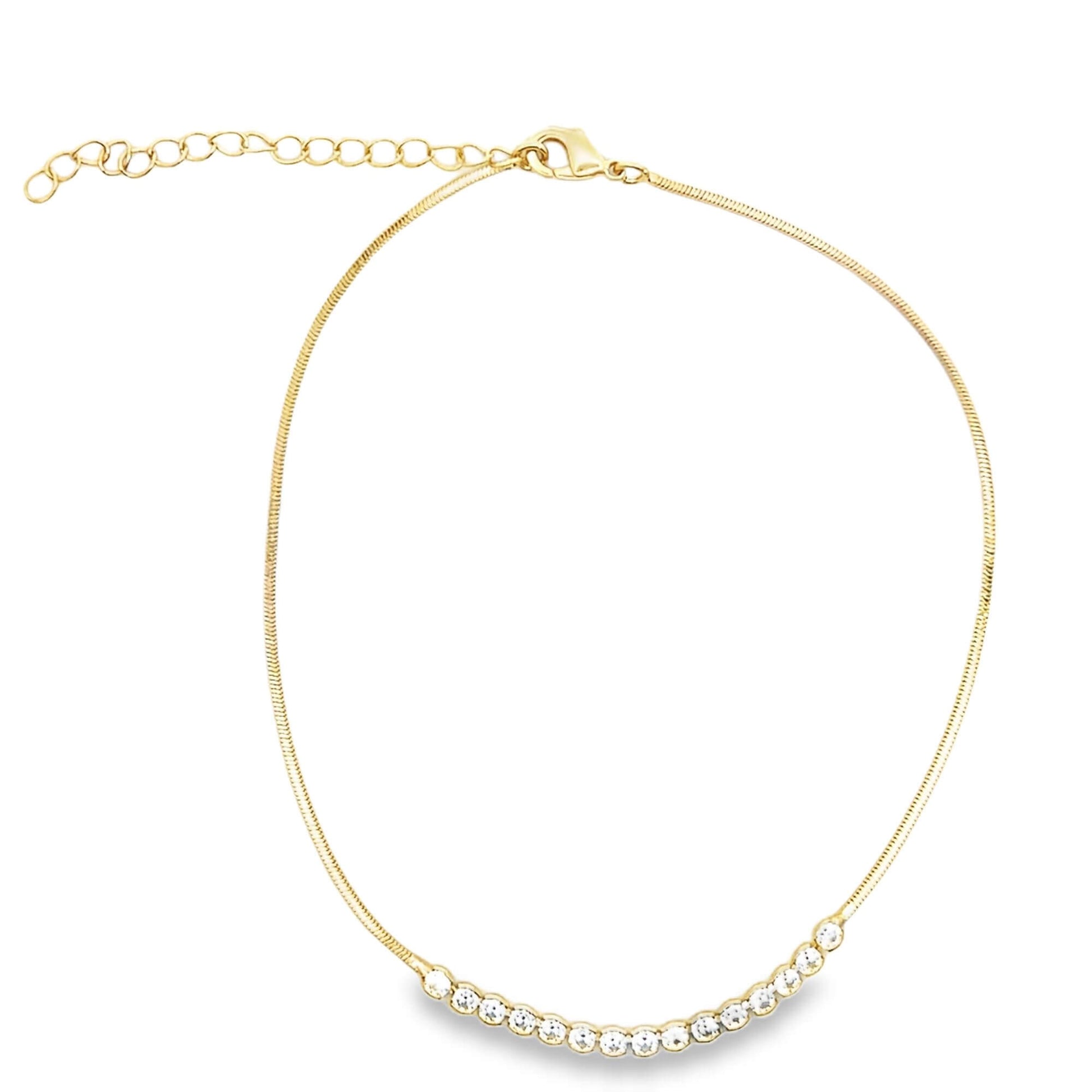 A delicate gold chain necklace sparkles with a curved row of cubic zirconia stones at the center.