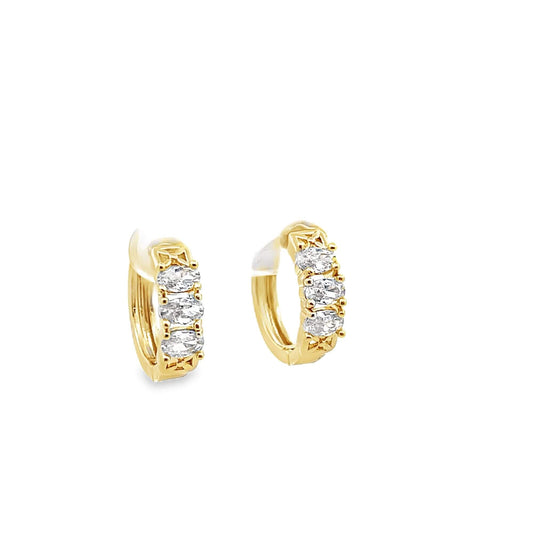 A pair of gold huggie hoop earrings sparkles with three inset oval-cut cubic zirconia stones against a clean white background.