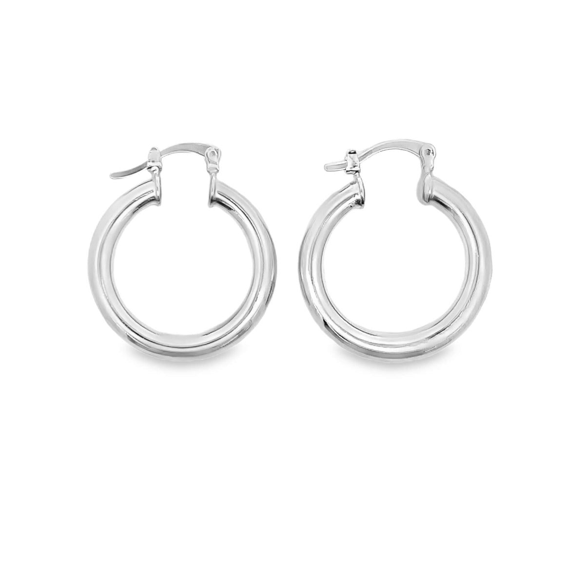 A pair of polished silver hoop earrings rest on a clean white background.