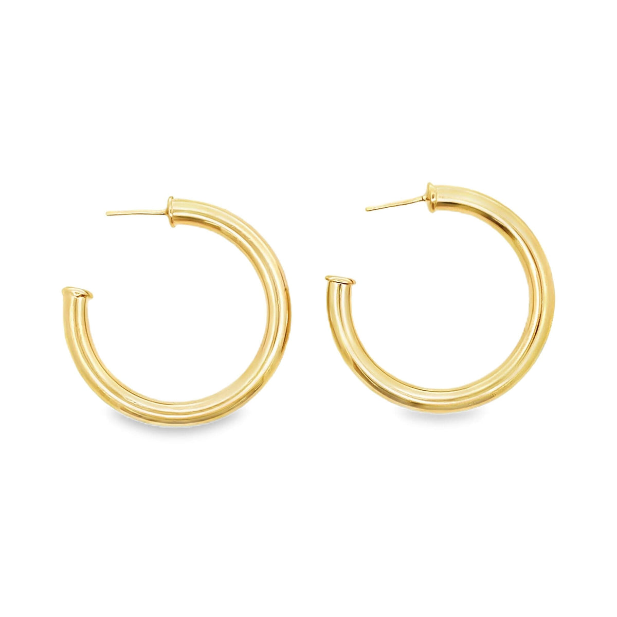 A pair of polished gold hoop earrings rests against a clean white background.