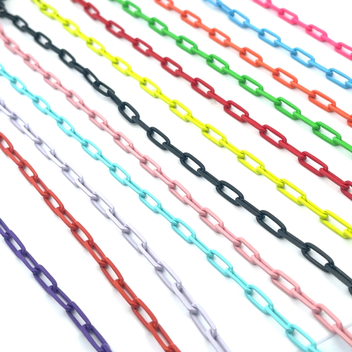 Multiple colorful enamel link chains fan out diagonally across a clean white background, showcasing a vibrant rainbow of vibrant jewelry supplies.