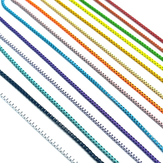 Multiple colorful metal box chains span diagonally across a clean white background, showcasing a vibrant rainbow spectrum from red and green to blue and purple.