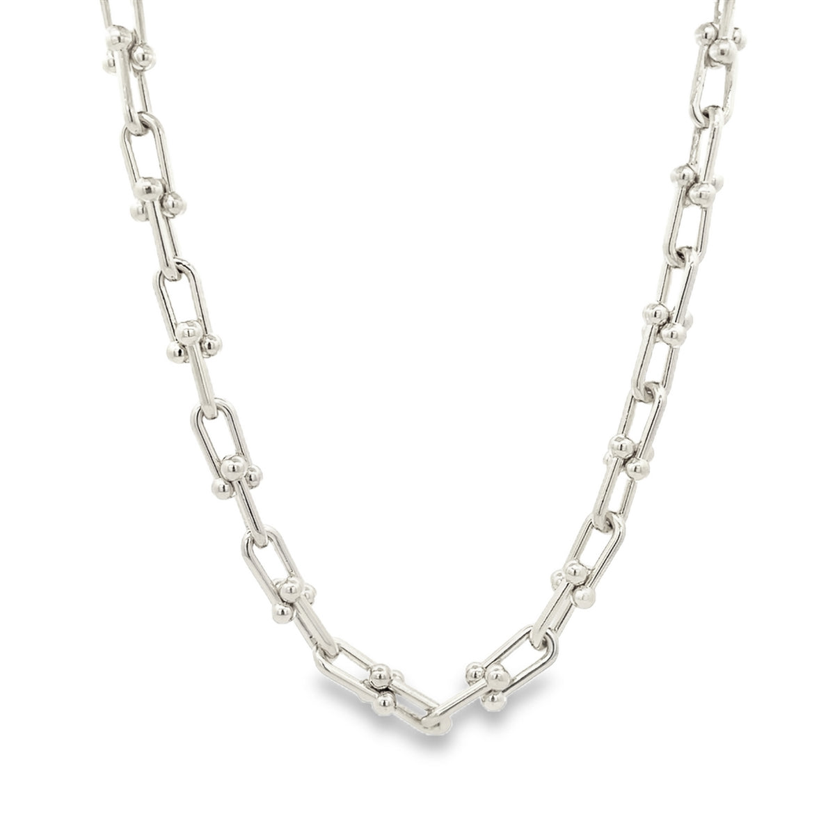 A polished silver link chain necklace rests in a gentle curve against a clean white background.