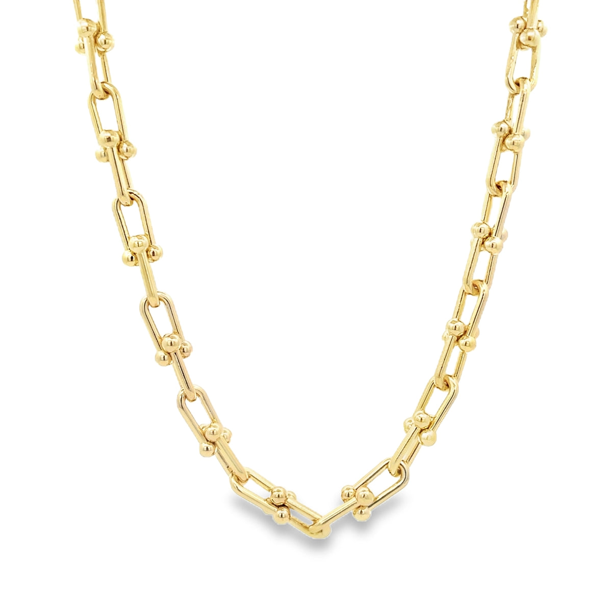 A polished gold paperclip link necklace displays alternating elongated links accented with small spherical beads against a white background.