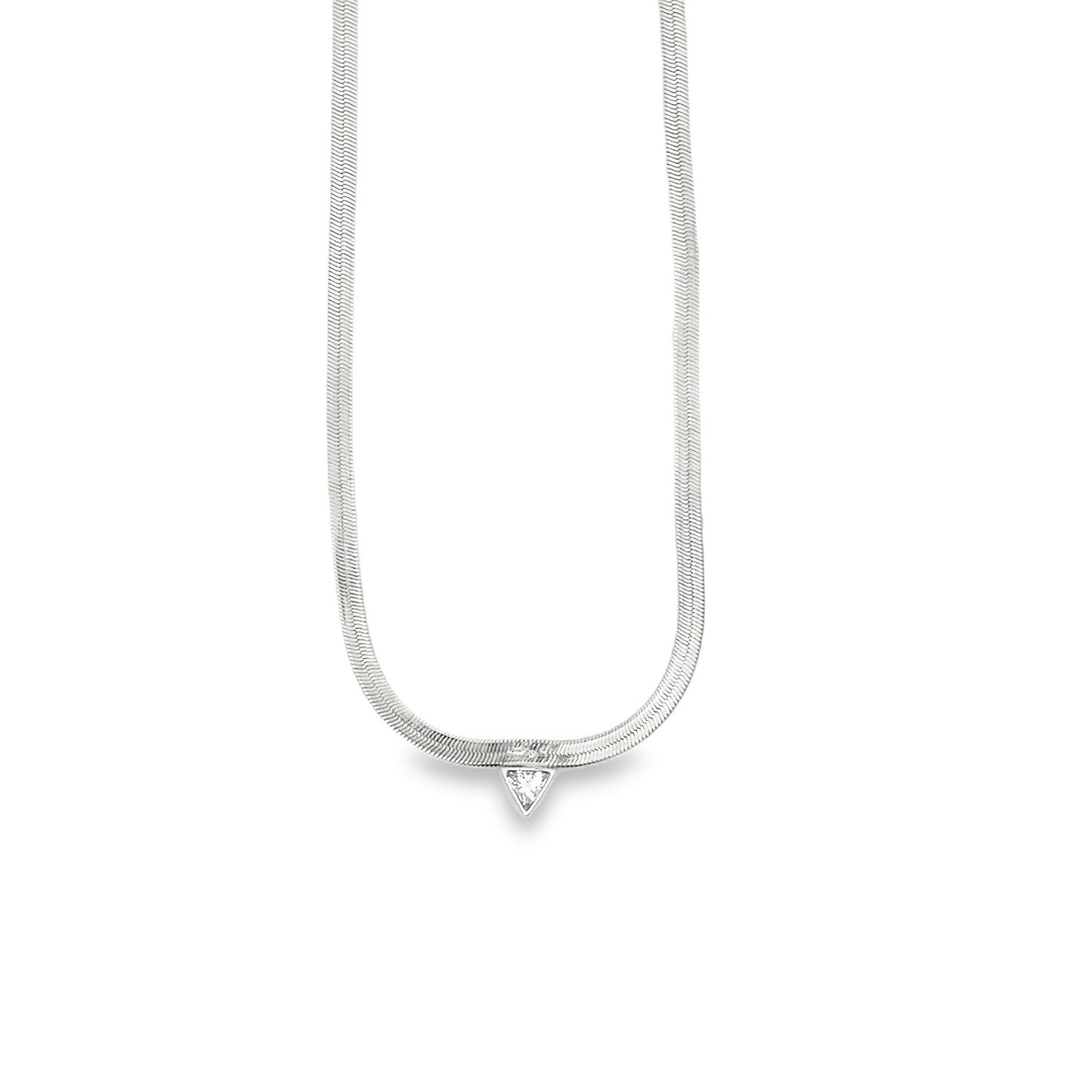 A delicate silver herringbone chain necklace features a dangling triangular gemstone pendant against a plain white background.