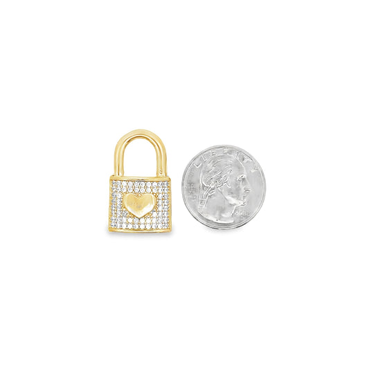 A gold padlock charm encrusted with cubic zirconia stones and a central polished heart sits next to a US quarter coin for scale.