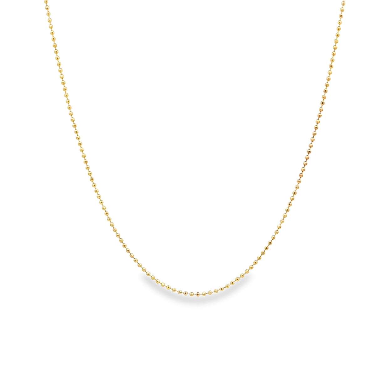 A delicate gold bead chain necklace drapes gracefully against a clean white background.