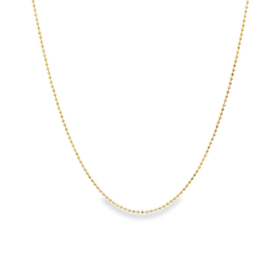 A delicate gold ball chain necklace drapes gracefully against a clean white background.