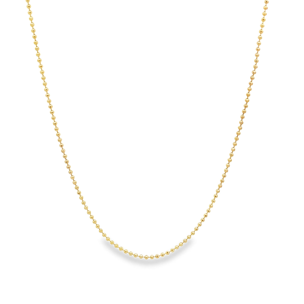 A delicate gold ball chain necklace drapes gracefully against a white background.