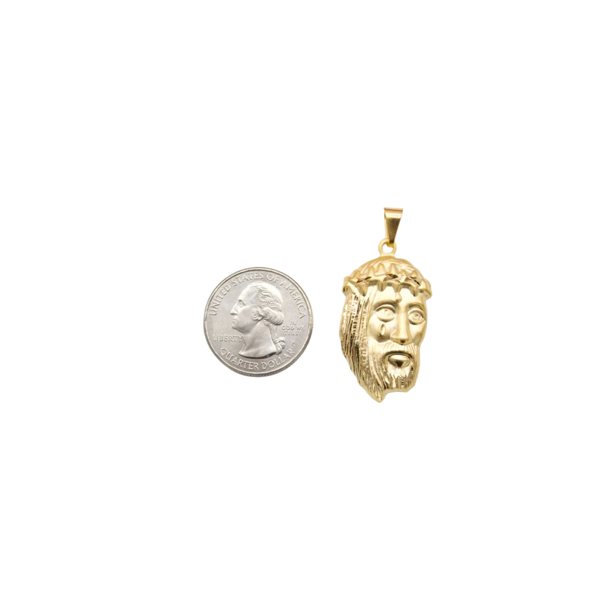 A gold Jesus piece pendant rests next to a US quarter coin for scale.