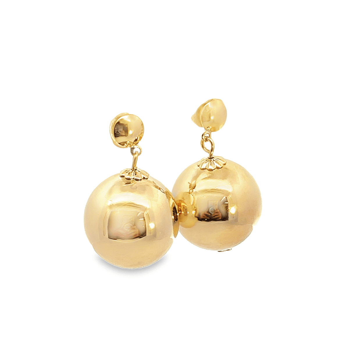 A pair of polished gold ball drop earrings gleams against a clean white background.