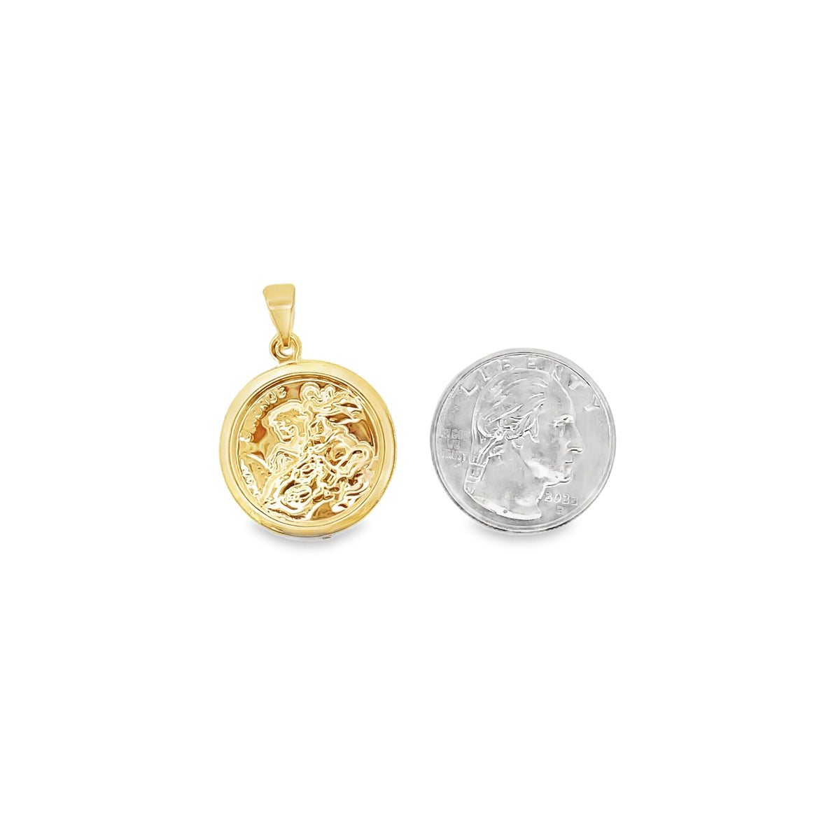 A round gold pendant featuring a detailed depiction of Saint George slaying the dragon rests beside a US quarter coin for scale.