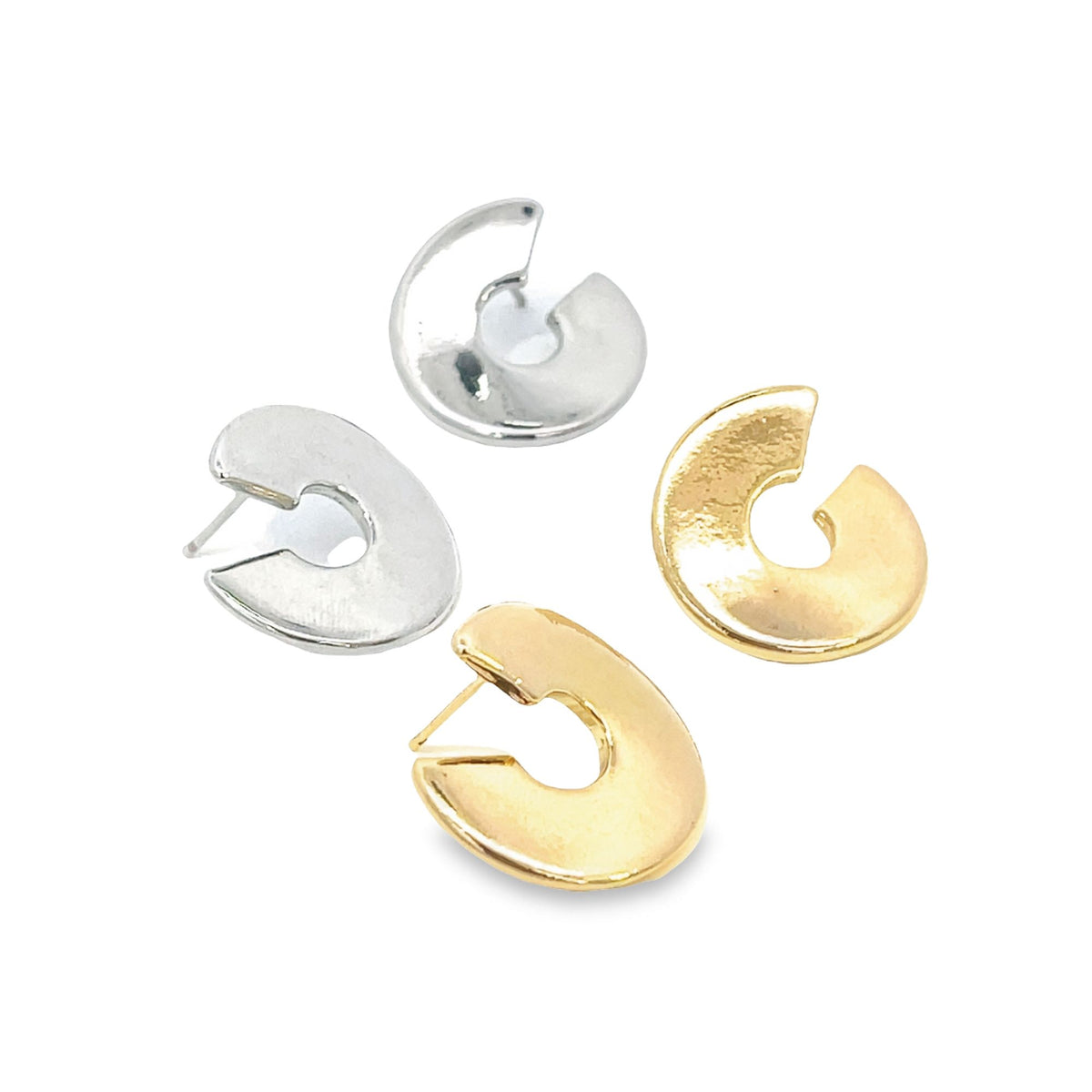 Two pairs of modern minimalist earrings in polished gold and silver rest on a white surface.