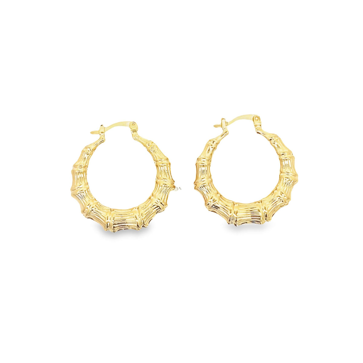 A pair of textured gold bamboo hoop earrings rests against a clean white background.