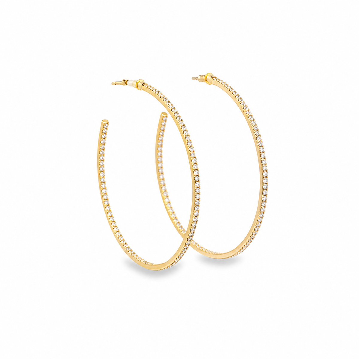 A pair of elegant gold hoop earrings encrusted with sparkling diamonds rests against a clean white background.