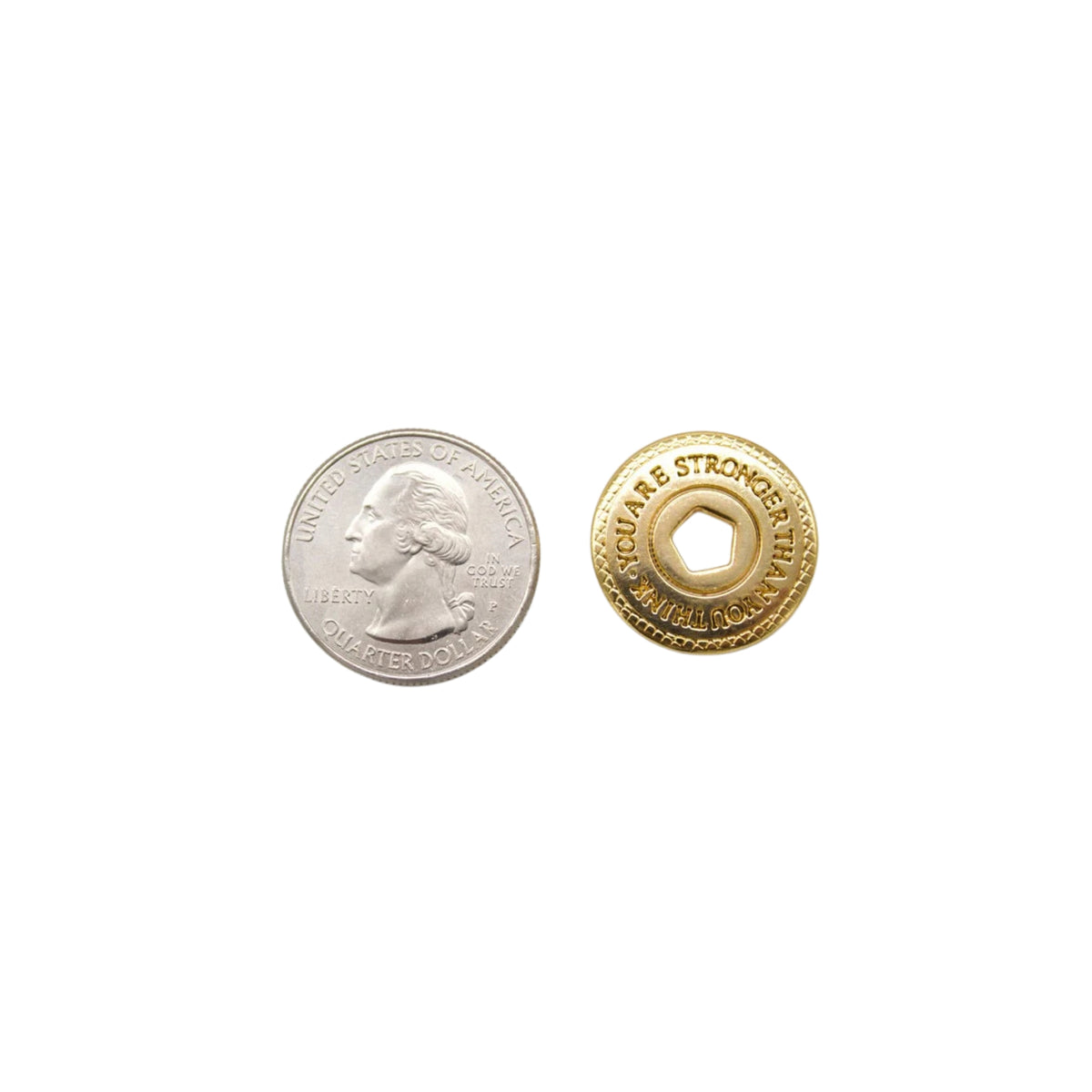 A US quarter coin rests beside a gold token inscribed with the words "YOU ARE STRONGER THAN YOU THINK" on a plain white background.