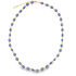 A gold chain necklace displays a continuous series of blue and white evil eye beads against a white background.