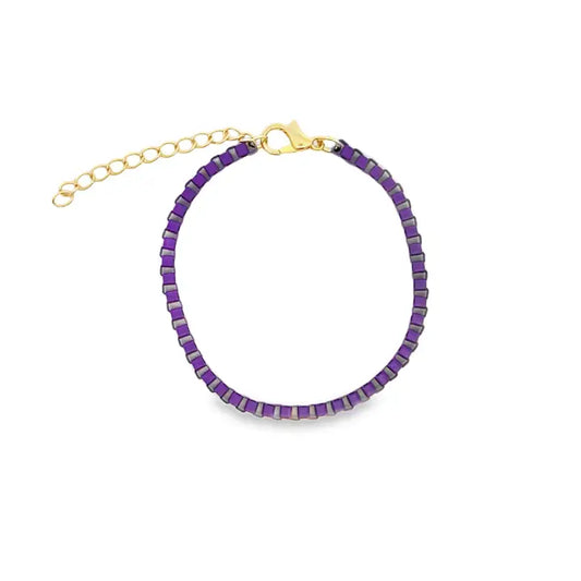 A delicate purple beaded bracelet features a gold-tone clasp and an adjustable chain extension against a plain white background.