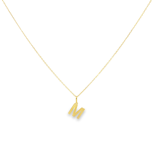 A delicate gold chain holds a shiny initial M pendant against a plain white background.