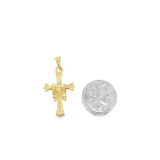 A detailed gold cross pendant rests beside a US quarter for size comparison.