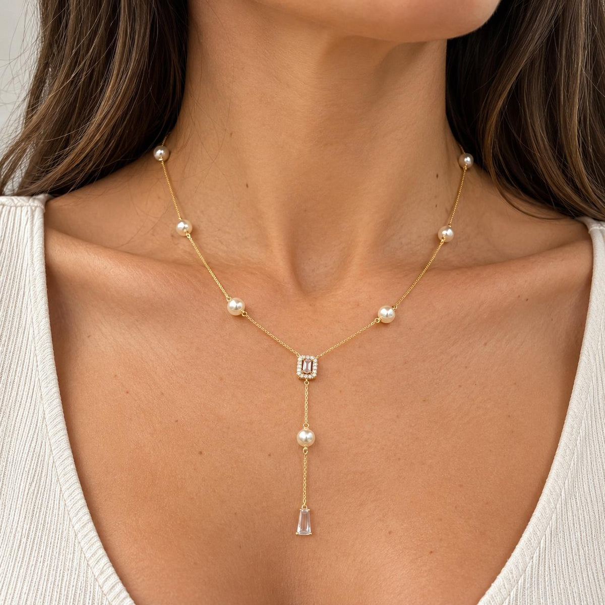 Shop the Pearl Station Lariat Necklace featuring pearl accents, a pavé CZ centerpiece, and elegant cascading crystal drops for a sophisticated statement look.