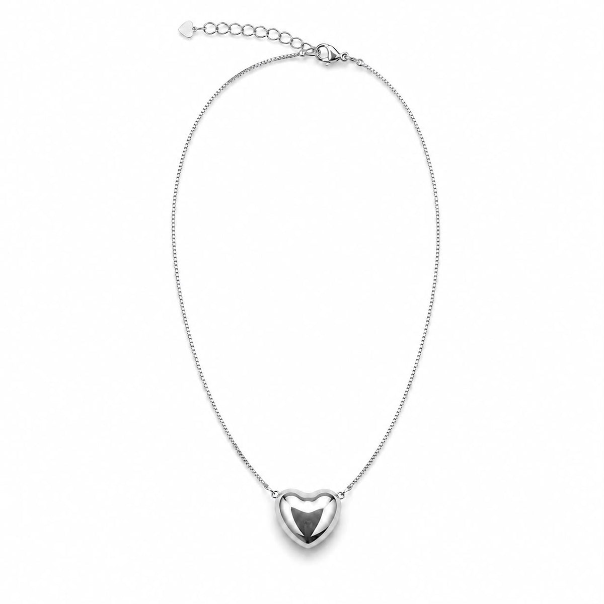 A delicate silver chain necklace features a polished puffy heart pendant centered against a clean white background.