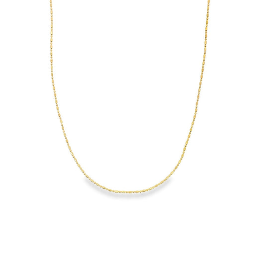 A delicate gold chain necklace with a textured bead design drapes gracefully against a white background.