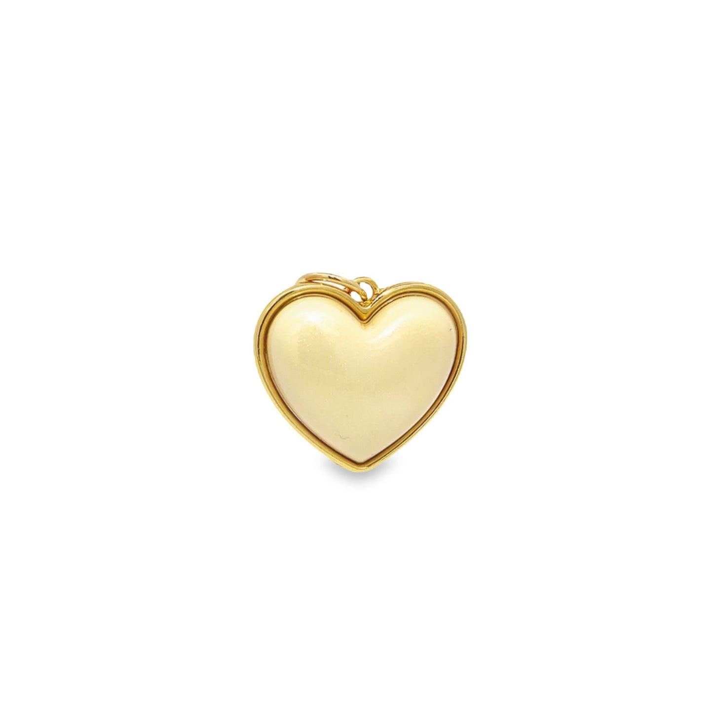 A cream-colored heart-shaped pendant featuring a polished gold rim rests against a plain white background.