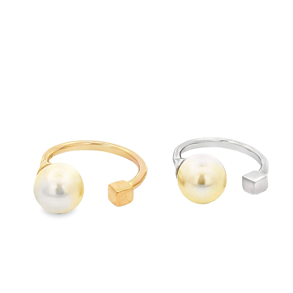 Two open-band rings feature a large pearl on one end and a small cube detail on the other, displayed side by side in gold and silver finishes.
