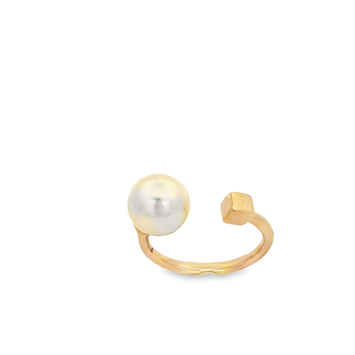 A modern gold ring features an open design with a lustrous white pearl on one end and a small cubic detail on the other.