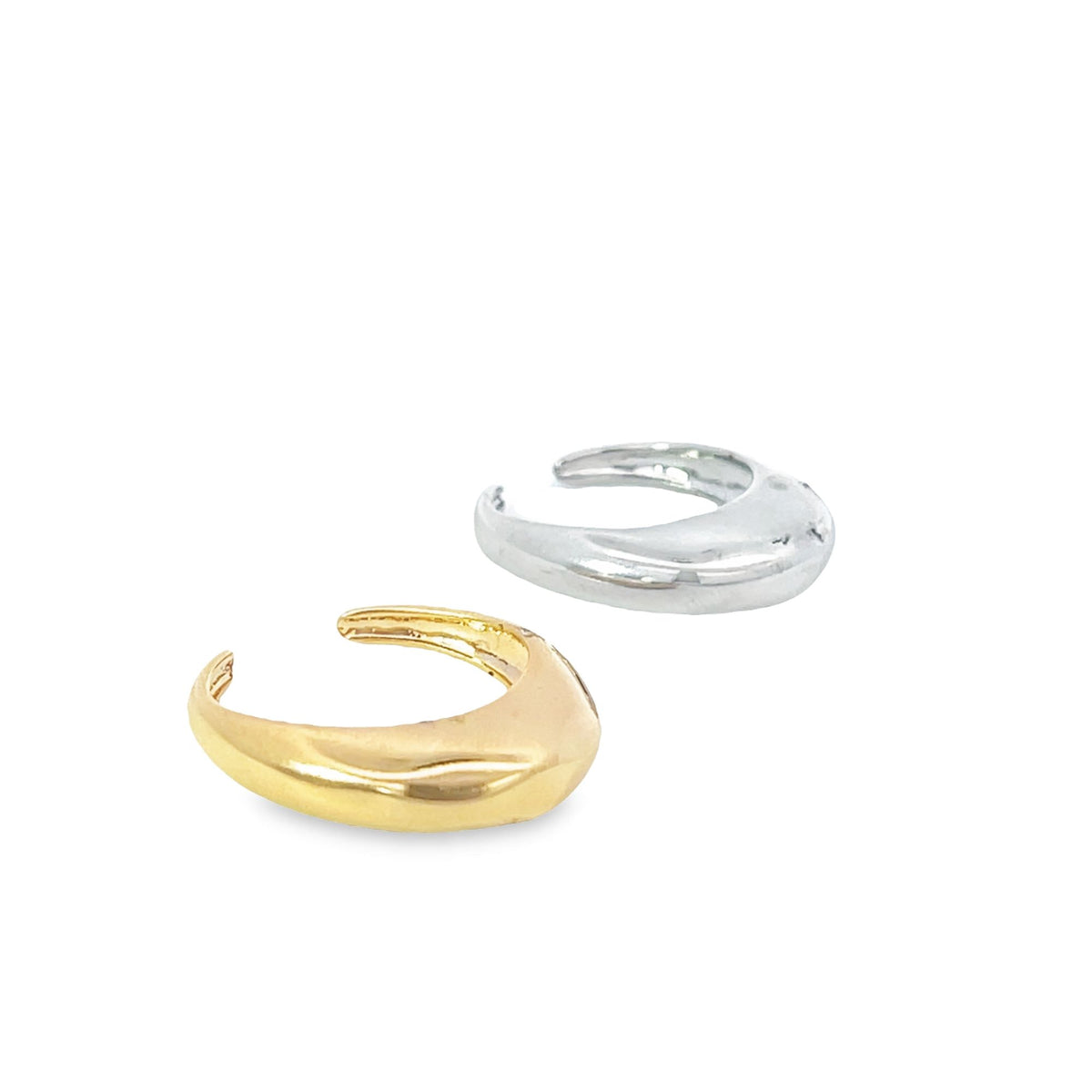Two chunky metal ear cuffs, one in gold and one in silver, rest side by side on a white background.