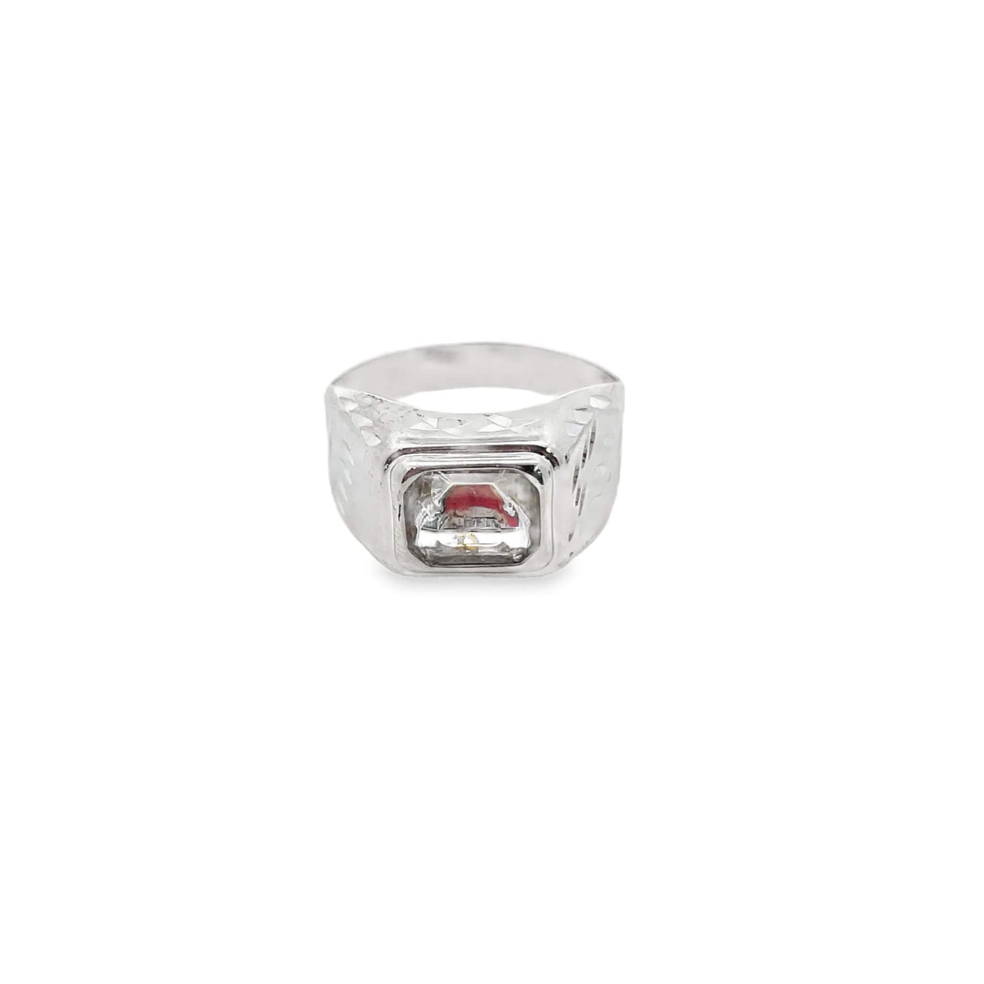 A silver men's signet ring features a rectangular clear stone with a red accent nestled inside its textured setting.