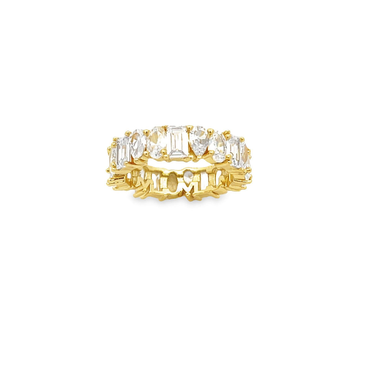 A gold eternity band features a row of mixed-cut cubic zirconia stones on a white background.