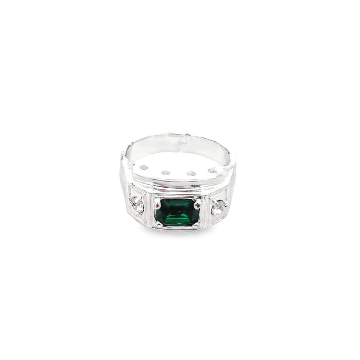 A silver cocktail ring features a prominent emerald-cut green center stone flanked by small accent gems against a clean white background.