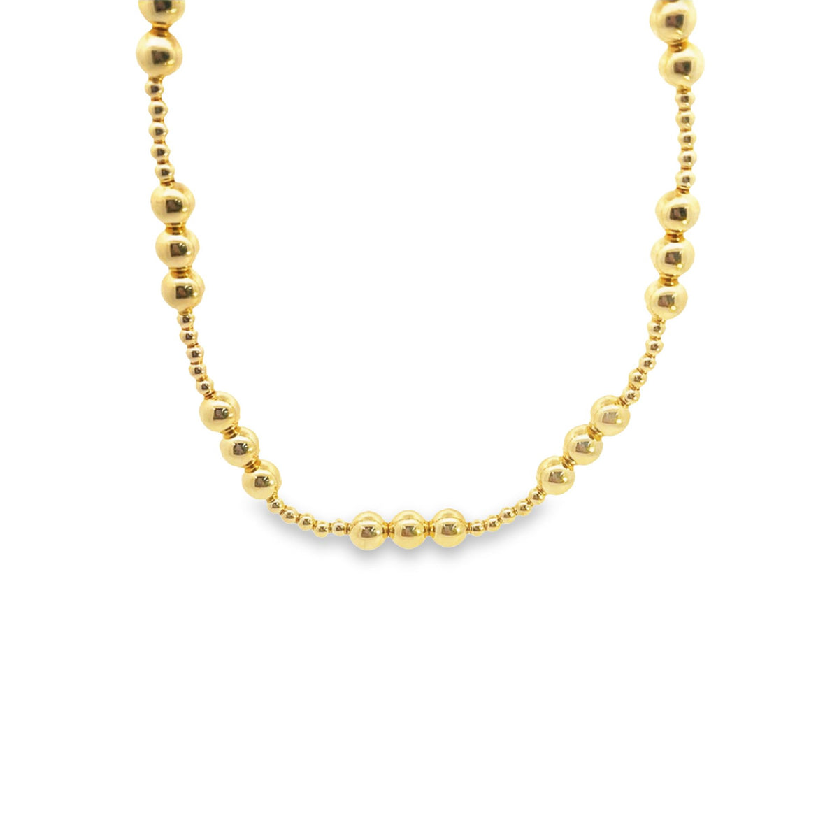 A gleaming gold bead necklace rests in a gentle curve against a clean white background.
