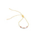 A delicate gold slider bracelet features sparkling cubic zirconia and vibrant red gemstones, finished with dainty pearl ends.